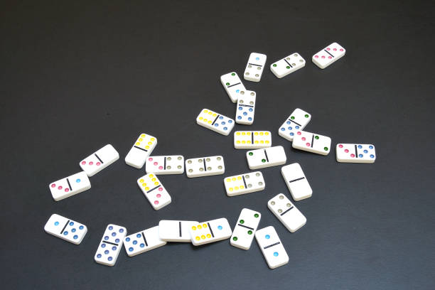 istock Pieces of dominoes on black table 1395890619