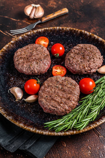 istock Hamburger grilled meat cutlets patties with herbs. Dark background. Top view 1395890655