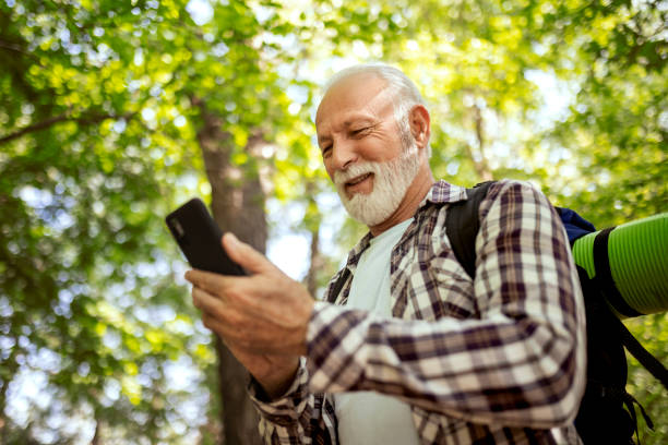 istock Senior man after hiking using smart phone 1395892590