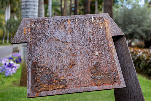 Rusty iron holder for a poster or sign in a public park in Santa Cruz which is the main city on the Spanish Canary Island Tenerife