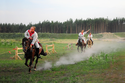 Kyiv, Ukraine. July 06, 2013. Three horsemen, two men and a woman, a performance in a traditional equestrian show on the occasion of the solar equinox