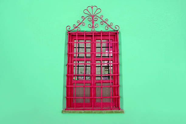 istock Raspberry red wrought iron vintage window on mint green colored wall 1395902144