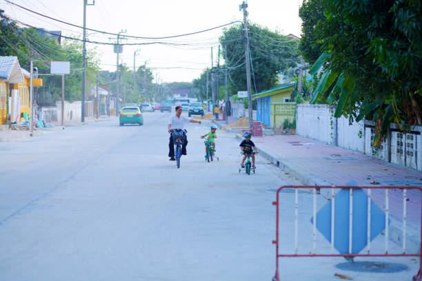 Thai man is exercising and learning cycling with children at daytime Scene is in residential district of Bangkok Ladprao with single homes. Area is low of traffic