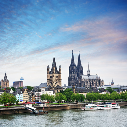 Riverbank of Rhine River in Cologne at sunset, Germany. Composite photo