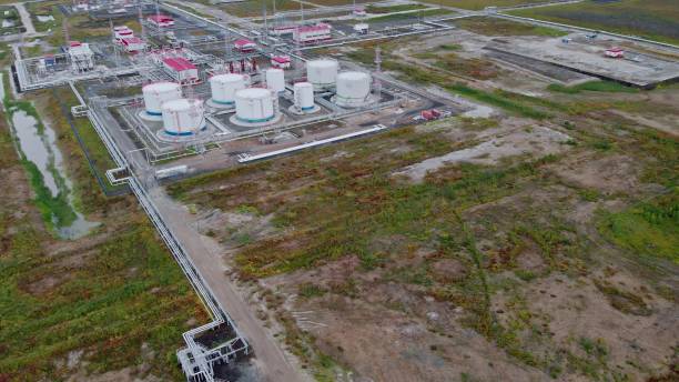 The drone flies over oil tanks at the oil field and primary processing and separation of associated petroleum gas from crude oil. A gas torch burns excess gas in the atmosphere, damaging the planet. el dron vuela sobre los tanques de petróleo en el campo petrolero y el procesamiento primario y la separación del gas de petróleo asociado del petróleo crudo. una antorcha de gas quema el exceso de gas en la atmósfera, dañando el planeta.