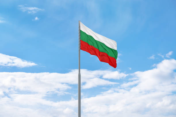 istock Bulgarian flag in front of blue sky and clouds. 1395910428