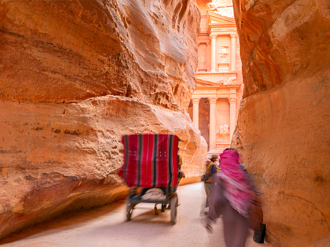 people in a horse carriage in a gorge, Siq canyon in Petra, Jordan. Petra is one of the New Seven Wonders of the World.