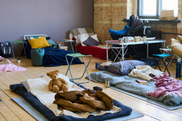 partie d’une chambre spacieuse avec des places de couchage sur du parquet pour les réfugiés - nombre de personnes photos et images de collection