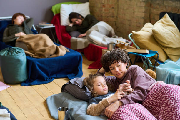 istock Cute boy with smartphone and his mother looking at screen while resting in bed 1395914379
