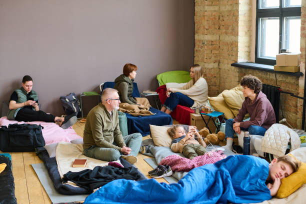istock Young woman talking to mature man while both sitting on sleeping places 1395914423