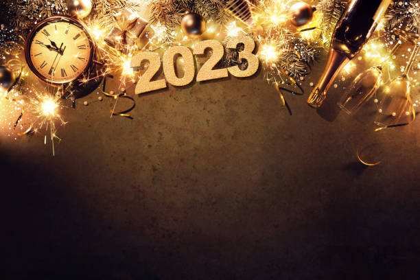 fondo navideño de nochevieja 2023 con ramas de abeto, reloj, bolas de navidad, botella de champán, caja de regalo y luces - new year fotografías e imágenes de stock