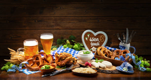 Festive served table with Bavarian specialities. Beer Fest menu Festive served table with Bavarian specialities. Sausages, pork knuckle,  pretzels, sweet mustard and beer mugs on rustic wooden table. Beer Fest menu oktoberfest food stock pictures, royalty-free photos & images