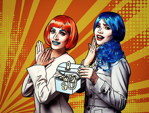 Portrait of young women in comic pop art make-up style on yellow - orange cartoon background. Female detectives investigate a crime with casket of jewelry in hands
