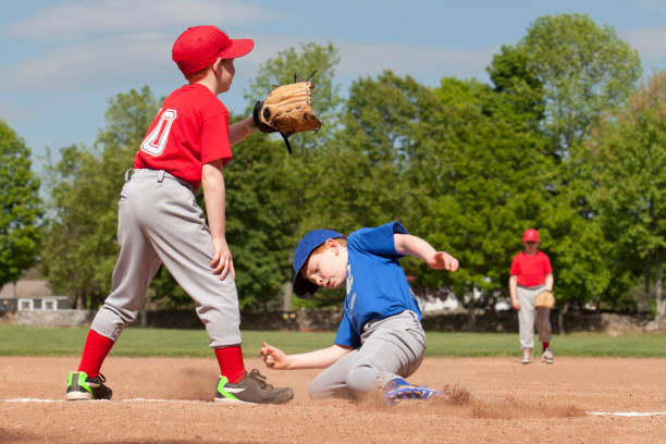 Baseball Boy sliding into base during a baseball game with Instagram style filter spring training stock pictures, royalty-free photos & images