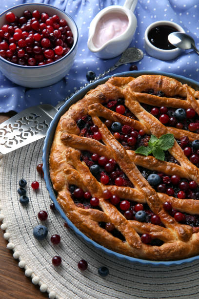 istock Delicious currant pie with fresh berries on wooden table 1395928847