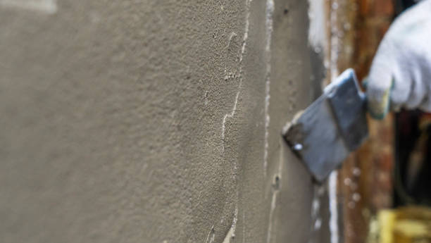 istock A plasterer applies plaster with a spatula to a brick wall. Wall renovation process. Defocused background. 1395929015