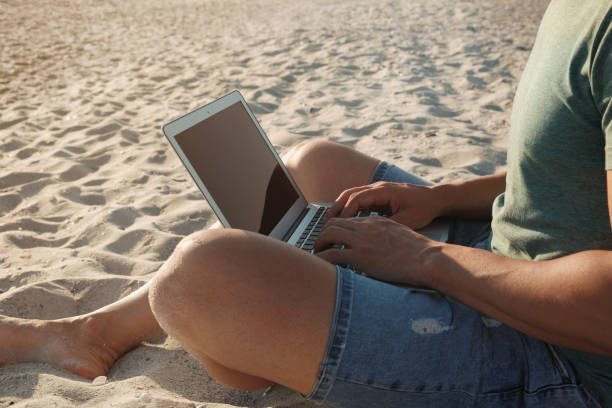 istock Man working with laptop on beach, closeup 1395934565