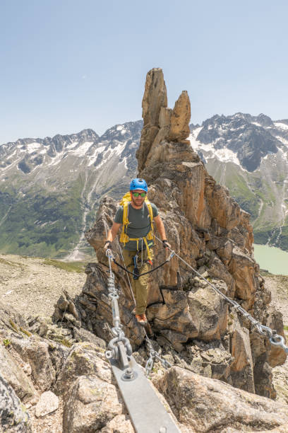 istock Young man on Via Ferrata crossing monkey bridge 1395934976