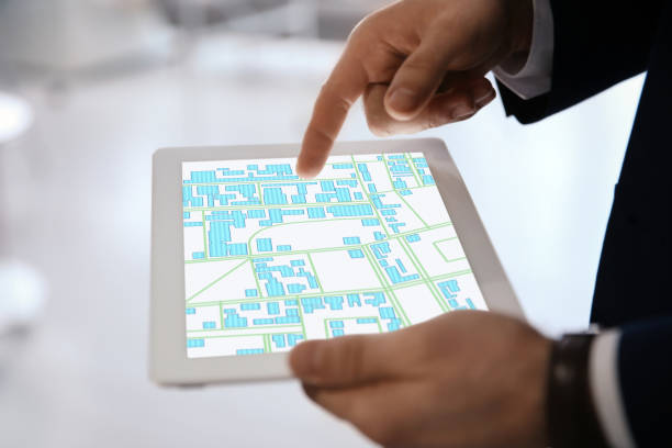 istock Man analyzing cadastral map on tablet indoors, closeup 1395935009