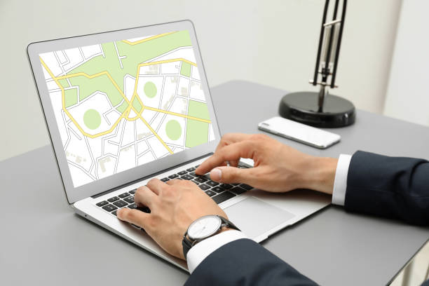 istock Man analyzing cadastral map on laptop at table, closeup 1395935012