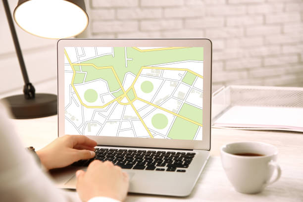 istock Woman analyzing cadastral map on laptop at table, closeup 1395935526