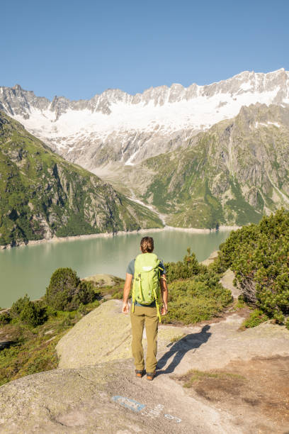 istock Hiker male contemplates glacier from a lookout 1395936251