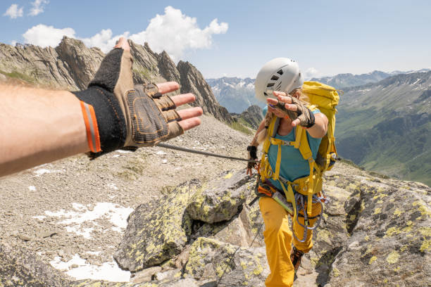 istock Climber helping teammate with a helping hand 1395936464