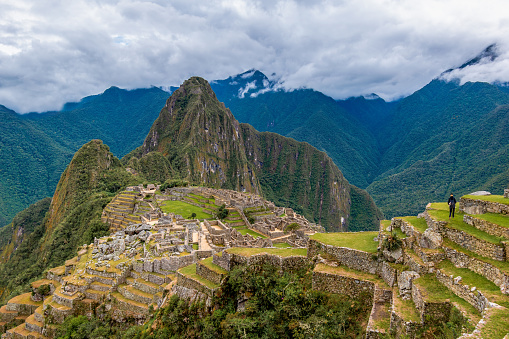 Machu Picchu, Aguas Calientes, Peru - May 4, 2022; Machu Picchu is a 15th-century Inca citadel located in the Eastern Cordillera of southern Peru on a 2,430-meter (7,970 ft) mountain ridge. It is located in the Machupicchu District within Urubamba Province  above the Sacred Valley, which is 80 kilometers (50 mi) northwest of Cusco. The Urubamba River flows past it, cutting through the Cordillera and creating a canyon with a tropical mountain climate.\n\nMost recent archaeologists believe that Machu Picchu was constructed as an estate for the Inca emperor Pachacuti (1438–1472). Often referred to as the \