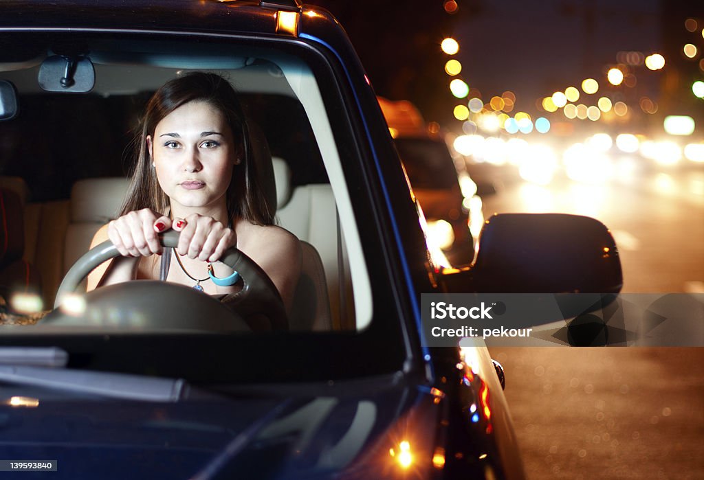 Młoda kobieta jazdy samochodem w nocy Miasto - Zbiór zdjęć royalty-free (Kierować)