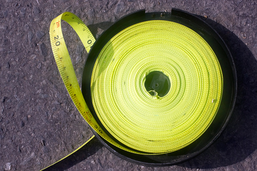 Reel of green large tape measure on floor. High angle view, harbor dock, Muros, A Coruña province, Galicia, Spain.