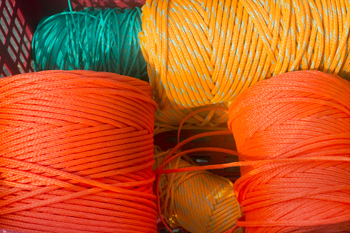 Balls of string, reels of multicolored strings, vibrant colors in the sunlight. Muros harbor, A Coruña province, Galicia, Spain.