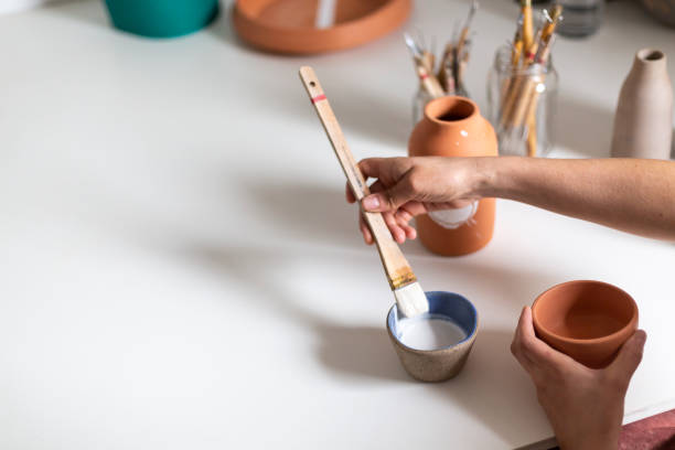 céramiste peignant un vase en argile dans un atelier - throwing wheel photos et images de collection