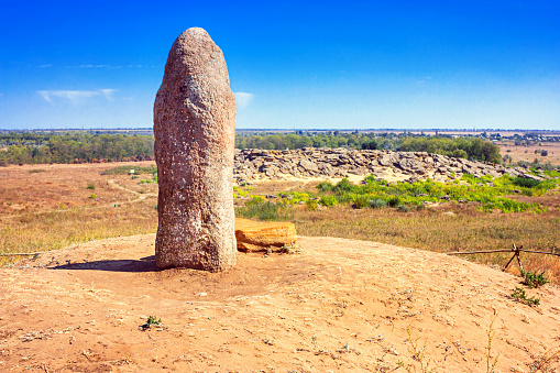 View of the ancient kurgan stela, stone idol against the backdrop of Kamyana Mohylain is an archaeological site in the Molochna River, Zaporizhzhia Oblast, Ukraine