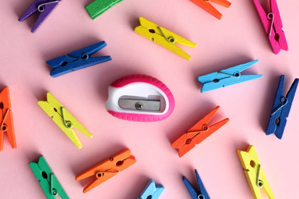 istock Colorful clothespins and sharpener on pink background, flat lay. Diversity concept 1395940656