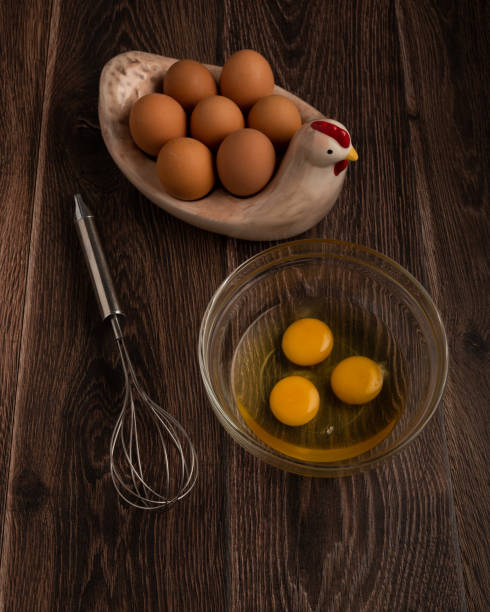 istock Eggs and a whisk on a dark wood background 1395942776