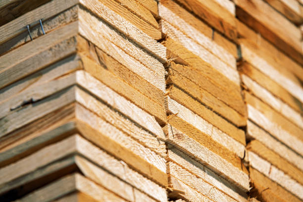 This image showcases a pile of neatly stacked wooden planks, varying in shades and textures, creating a rustic and organized appearance perfect for construction or carpentry themes.