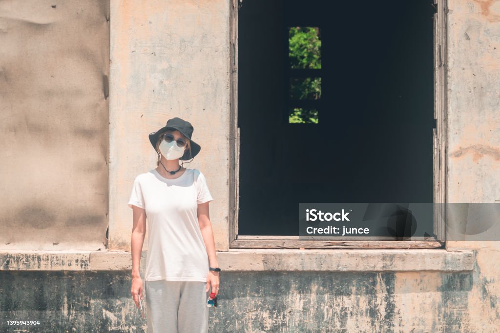 Woman taking photo with a creepy dark windows of an abandond house, Abandoned Stock Photo