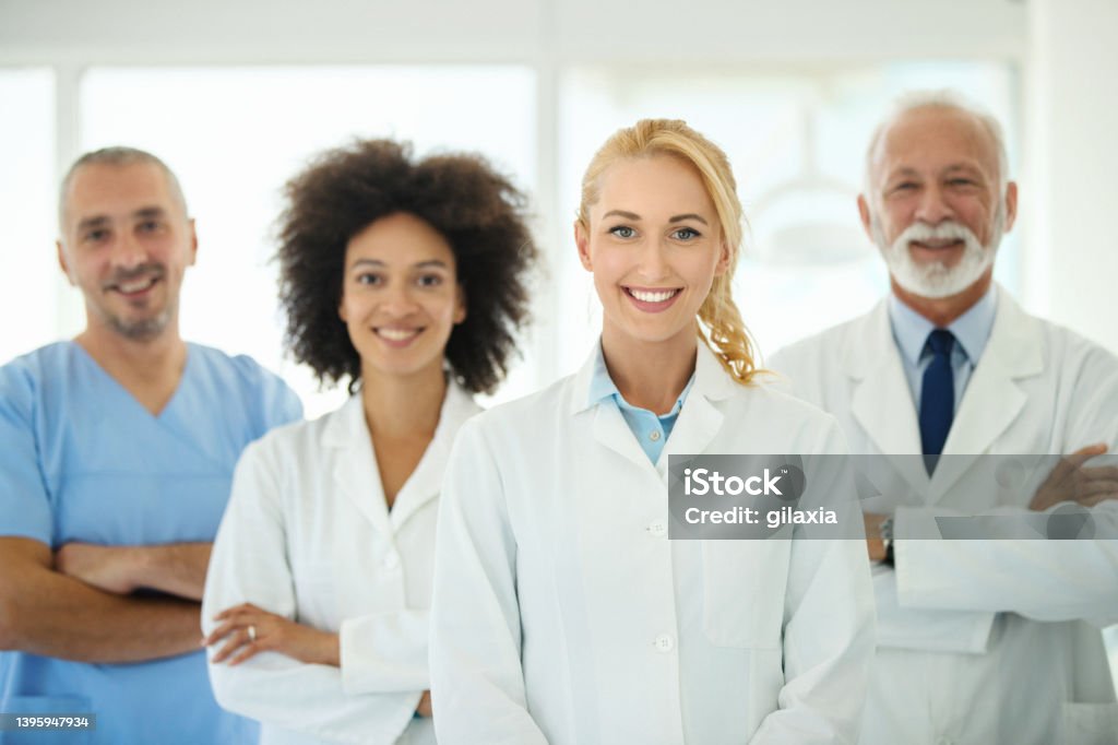 Group of dentists looking at camera. Closeup front view of mixed age and race group of dentists and/or doctors smiling to the camera. Dentist Stock Photo