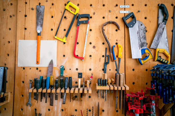 istock Shelf with hand tools for woodworking. Various carpenter hand tools hanging on the wall in the carpentry workshop. 1395948154