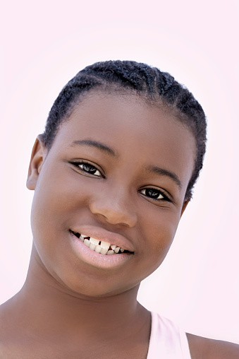 Portrait of a beautiful girl with cornrow braids, twelve years old, photo, pink background