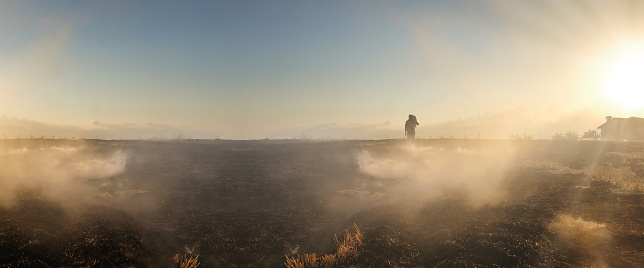 Farmer walking on misty field