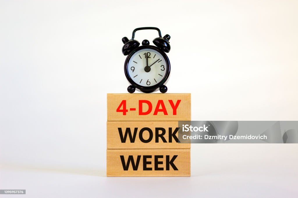 4-day work week symbol. Concept words '4-day work week' on wooden blocks. Black alarm clock. Beautiful white background. Copy space. Business and 4-day work week concept. Week Stock Photo