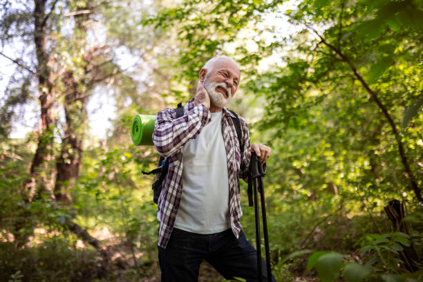 Senior hiker defending from mosquito Senior man hiking taking a break defending from mosquito bug bite stock pictures, royalty-free photos & images