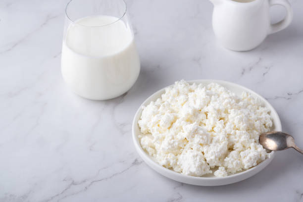 istock Bowl with fresh cottage cheese and milk on table. Space for text 1395958346