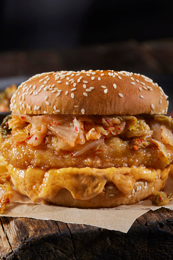 Sweet and Sour Crispy Fried Chicken Burger on a Brioche Bun with Kimchi, Sriracha Cheese Sauce and Fries