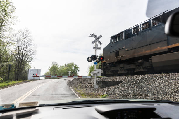 踏切を疾走するディーゼル貨物列車機関車 - crossing railroad track boundary gate ストックフォトと画像