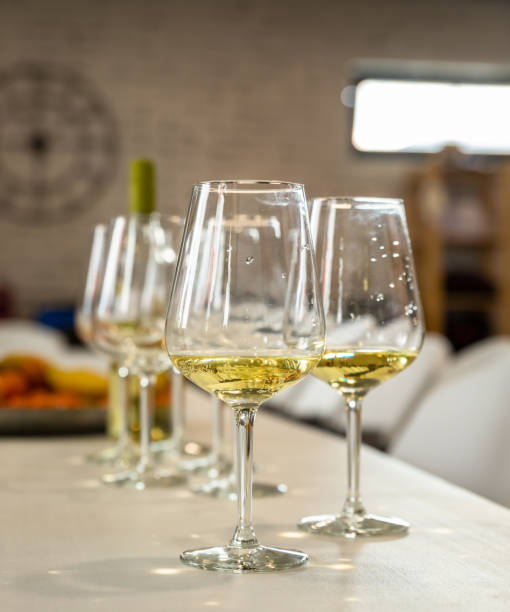 istock Different types of glasses for wine on table. Wine glasses with white wine and empty. Still life concept. Blurred background. 1395963456
