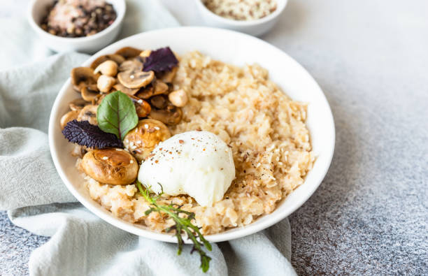istock Savory porridge for breakfast. Oatmeal or spelt flakes with poached egg, fried mushrooms and herbs. Healthy food. Keto diet. 1395963473