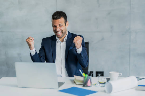 istock Cheerful businessman celebrating his success while working in the office. 1395963974
