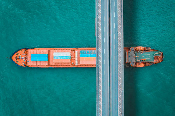 istock Aerial view of a cargo ship passing under bridge. 1395966824
